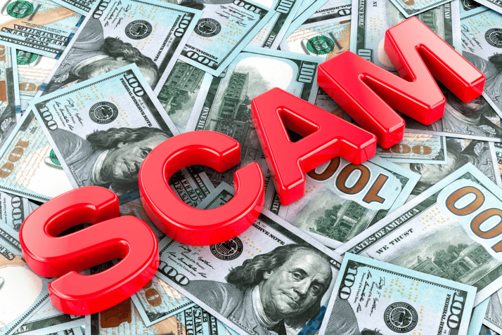 Chữ "SCAM" màu đỏ nổi bật trên nền tiền đô la Mỹ, cảnh báo về rủi ro lừa đảo và nhấn mạnh tầm quan trọng của sự trung thành trong kinh doanh và đầu tư.